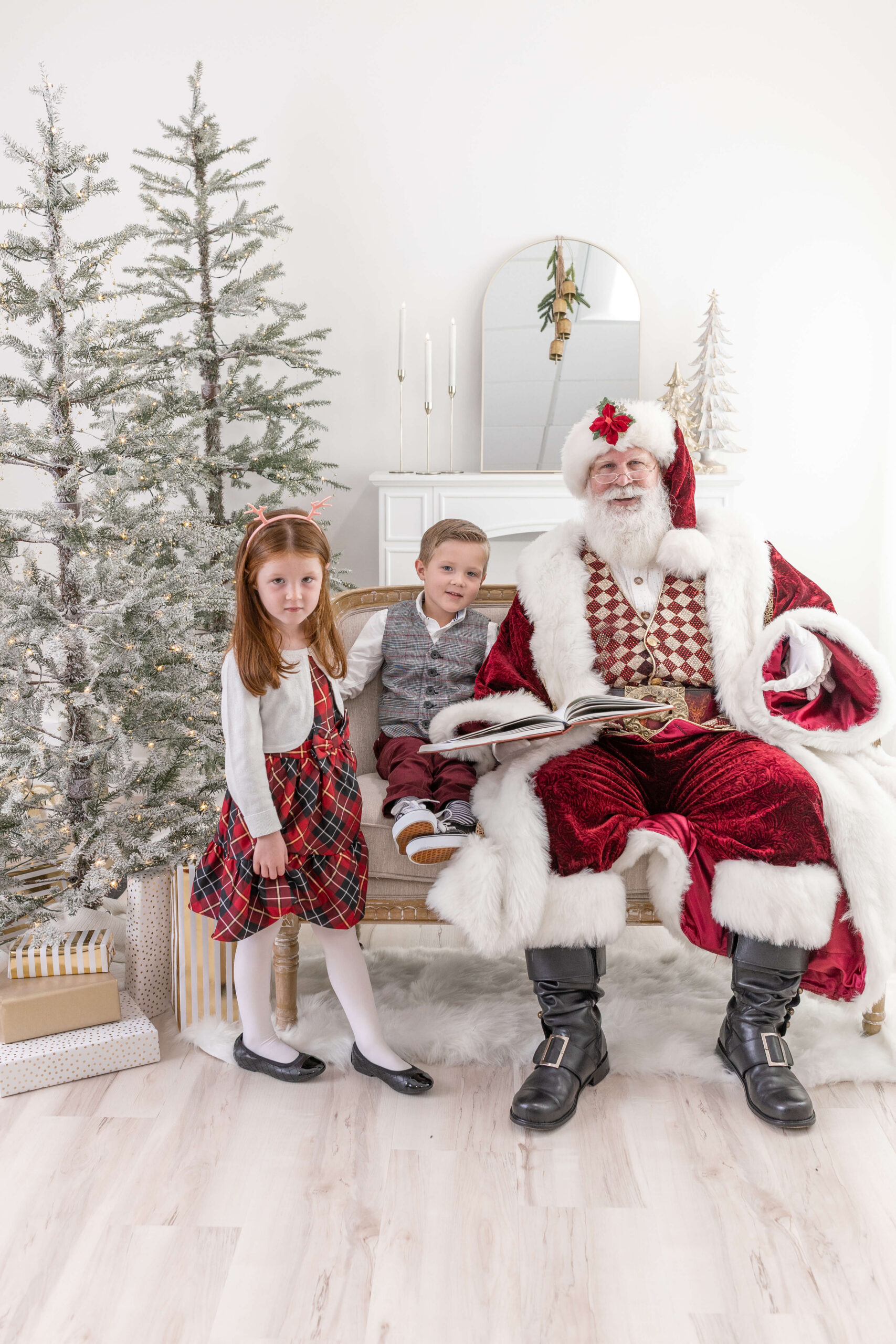 2 kids sitting next to Santa