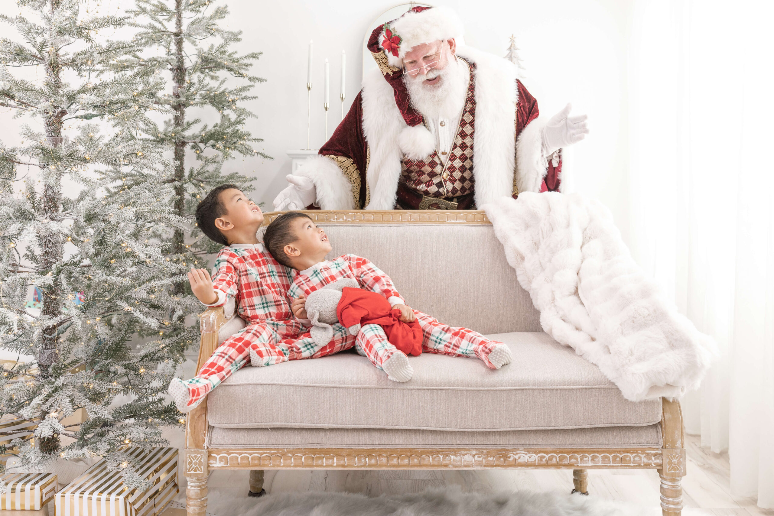 2 kids on a couch looking back at Santa