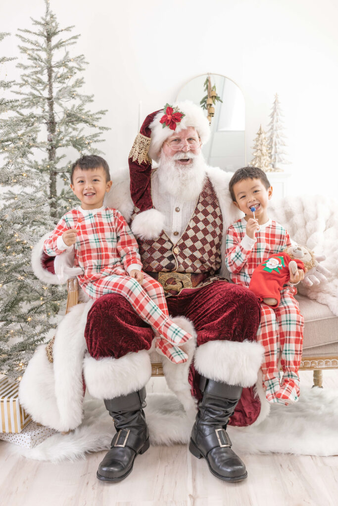 Santa with two smiling children in an Orange County photo studio