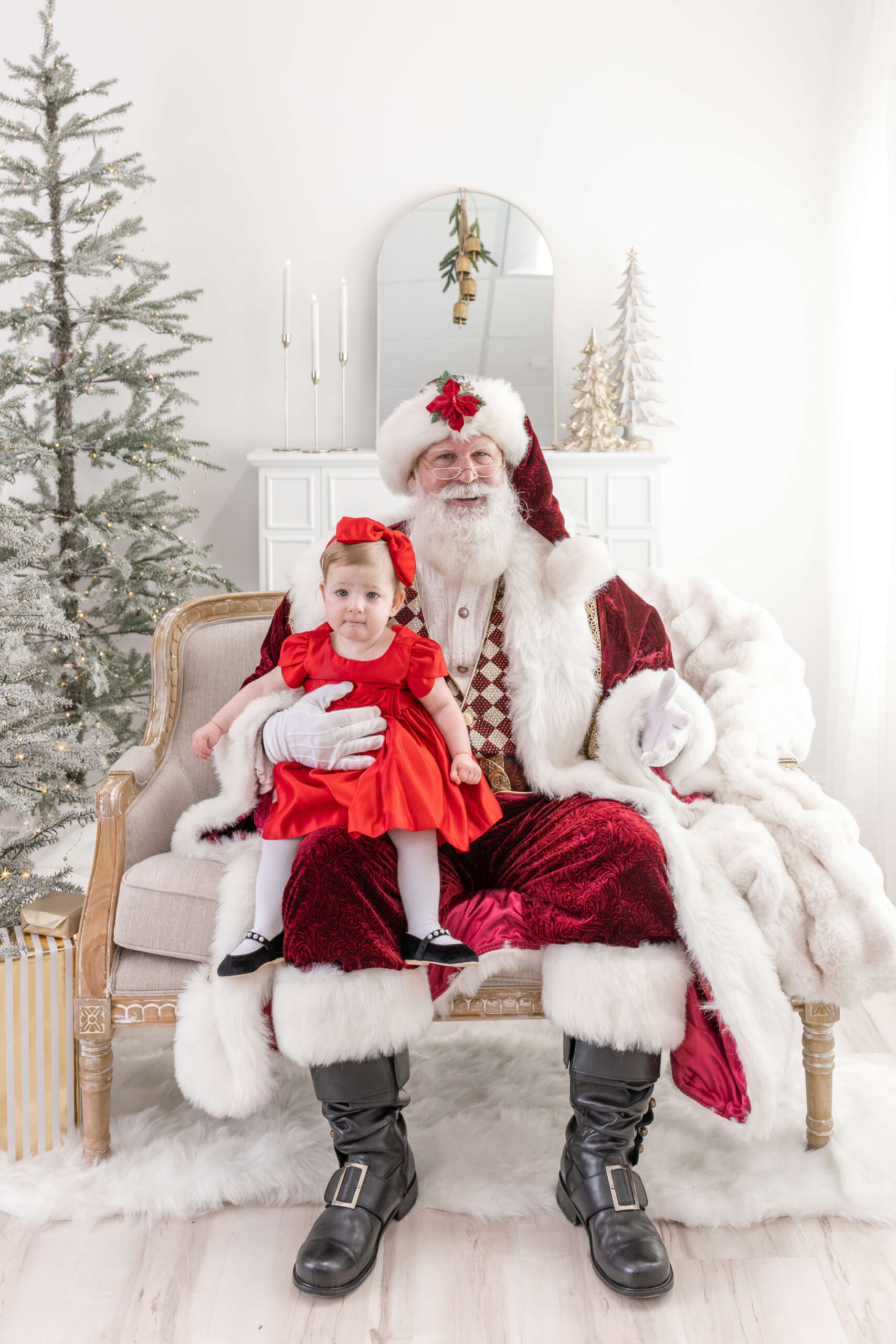 Girl in a red dress sitting on Santa's lap