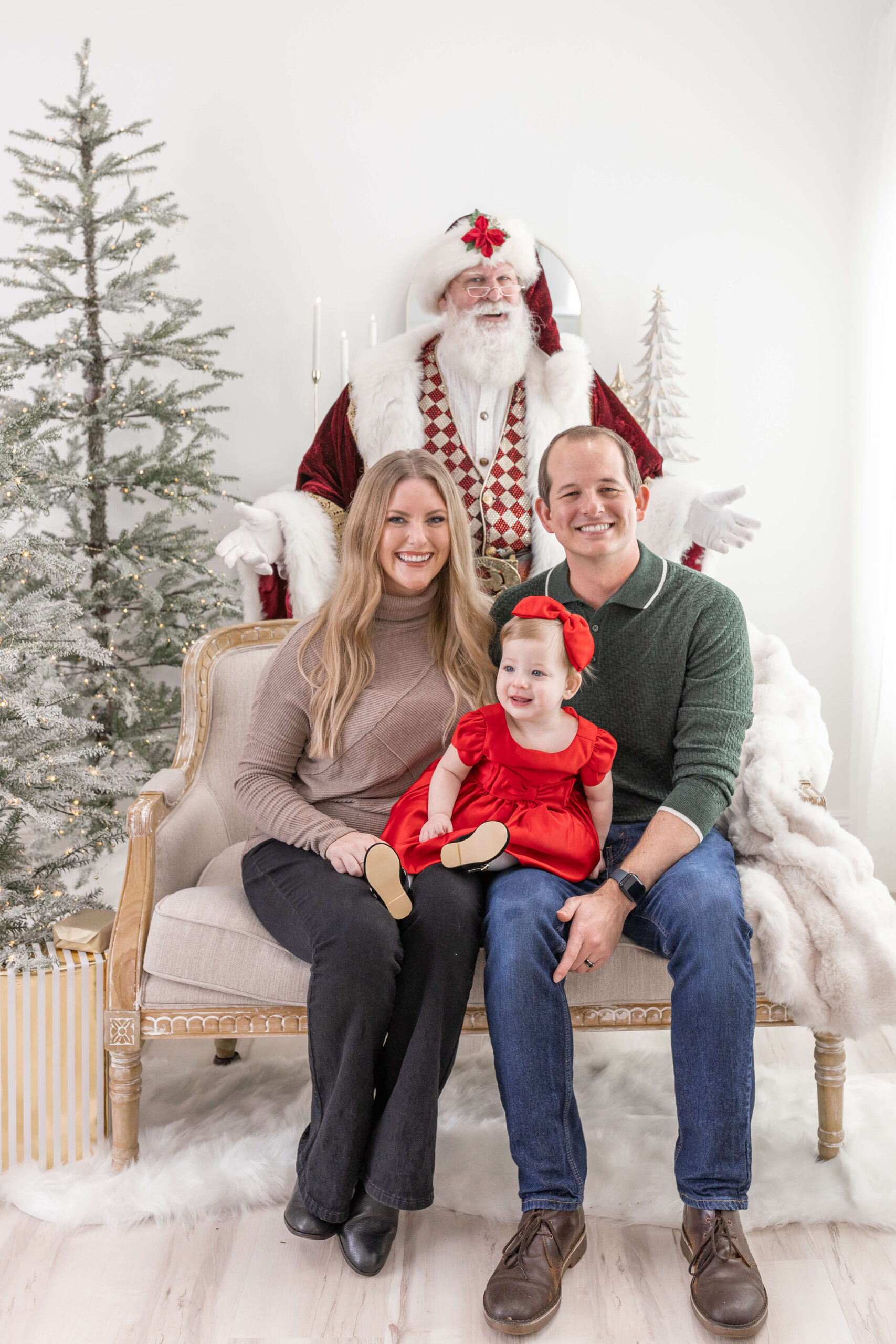 Family of 3 sitting on a couch with Santa