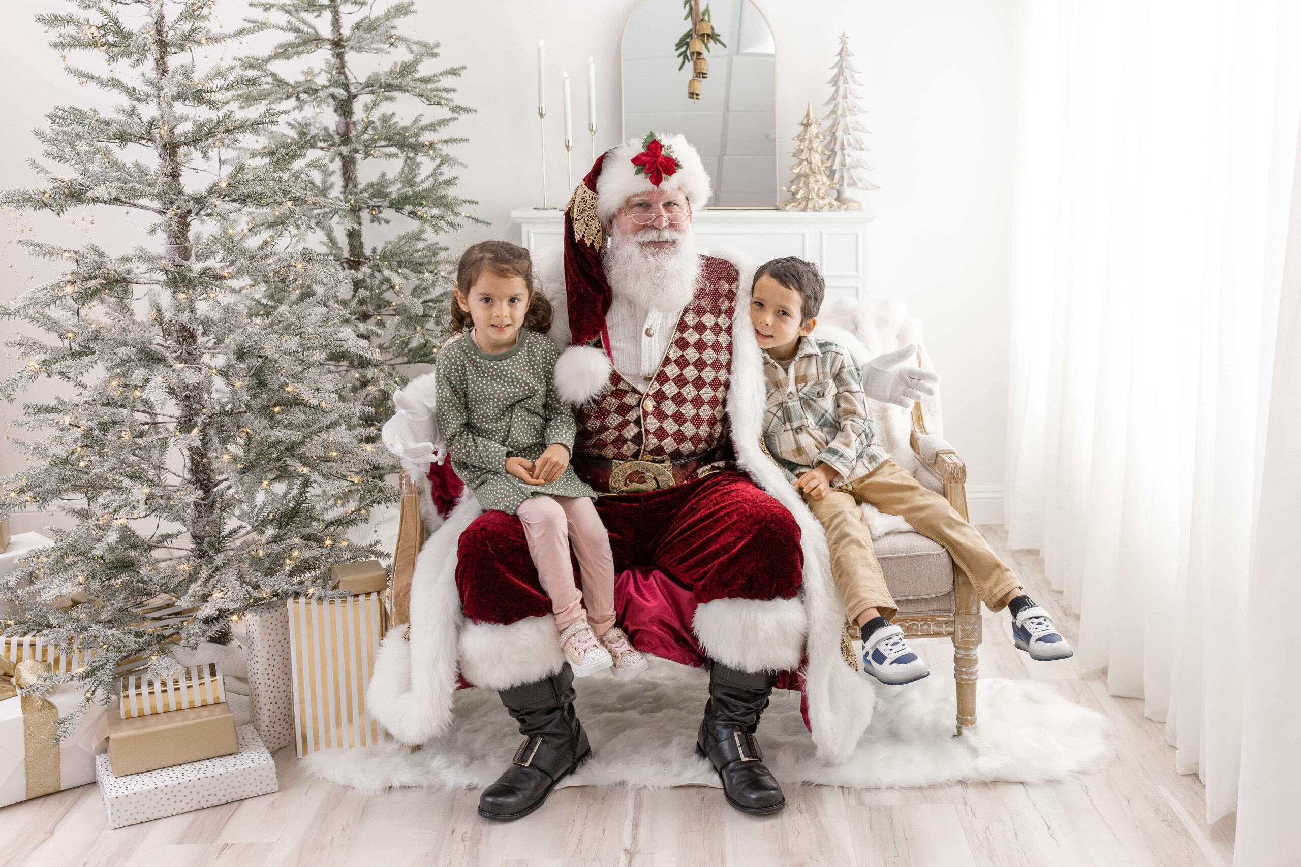 Brother and sister on a couch reading a book with Santa