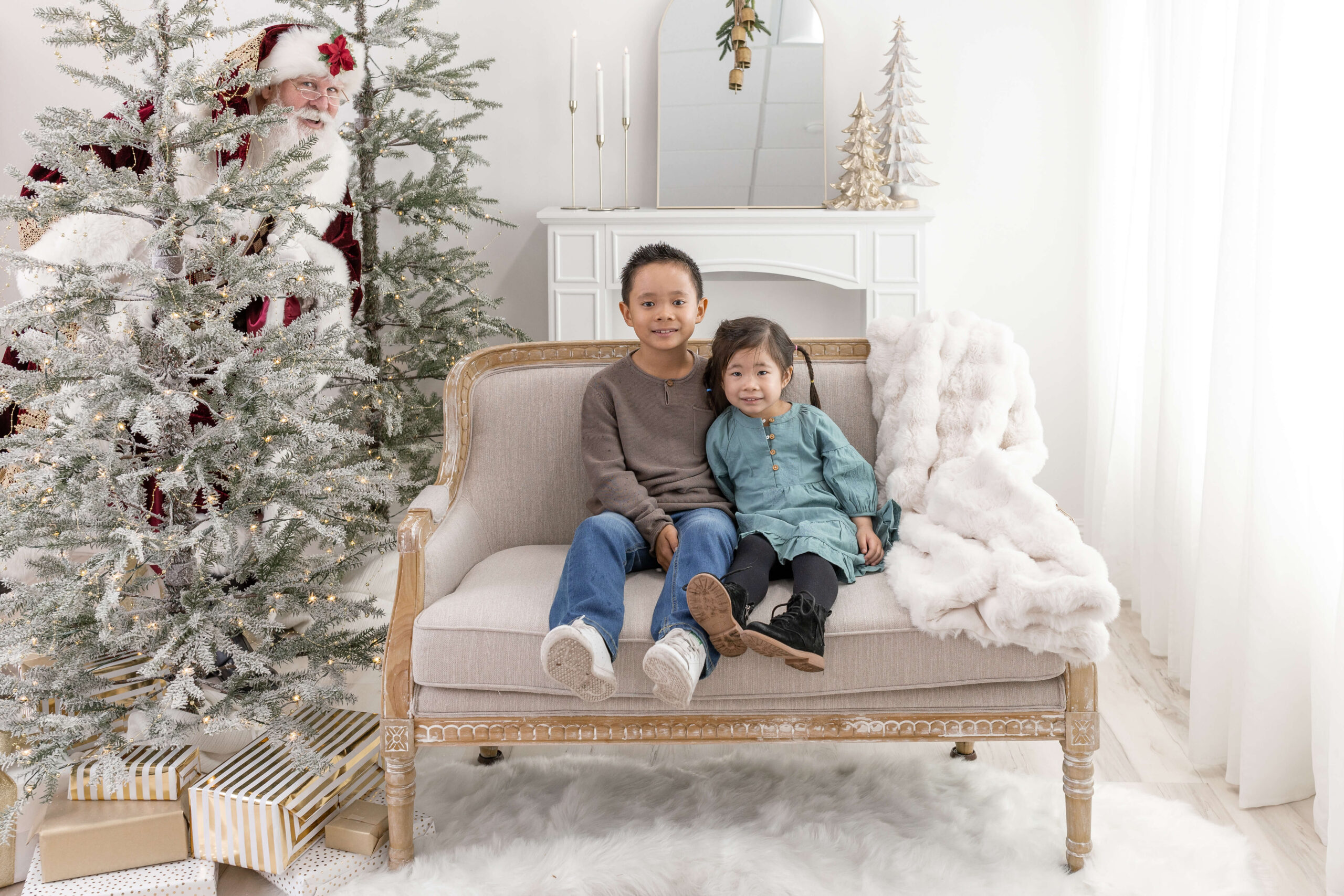 2 kids on a couch with Santa watching